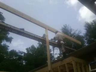 Carpenter setting a ridge beam over a new addition frame — Ice Dam Removal by Roofing Brothers in Paul