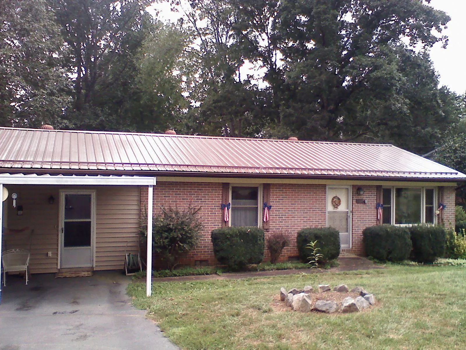 Bronze metal roof and carport on a brick ranch home — Roof Repair work by our crew in Paul